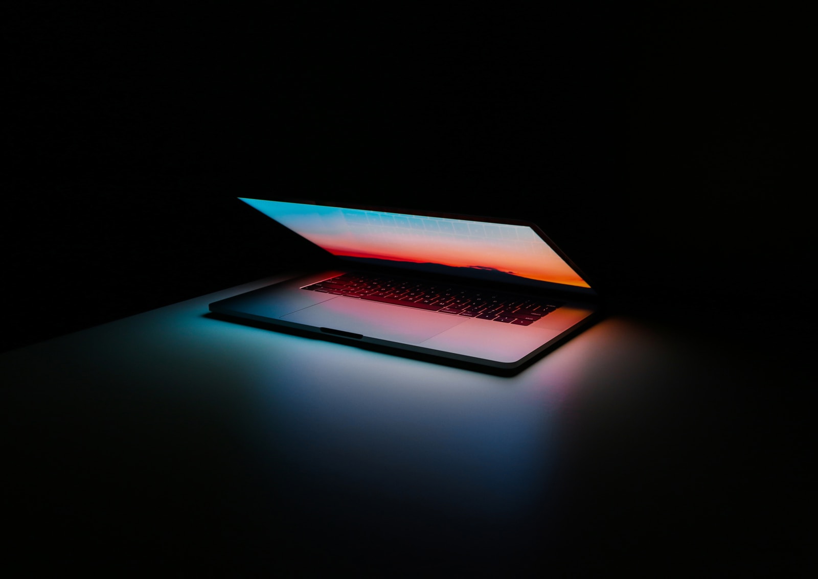 Laptop glowing in a dark room Laptop glowing in a dark room